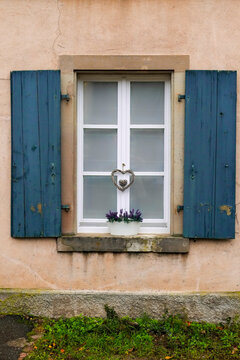 Decorative window with rustic shutters in Riquewihr