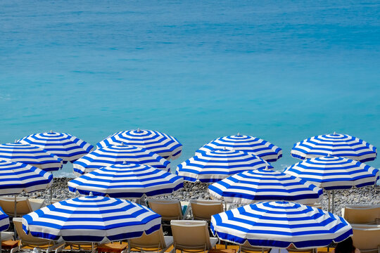 Blue striped beach umbrellas on the French Riviera in Nice