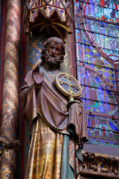 Religious statue with stained glass in historic church in Paris 