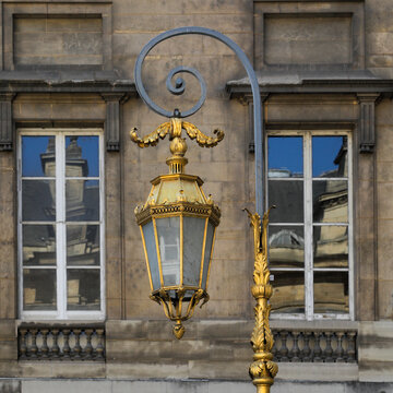 Gilded lantern on historic stone building in Paris 