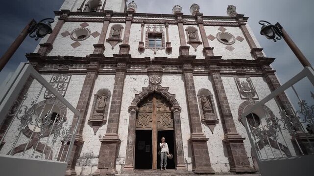 Mature woman walks around the San Ignacio Mission in Baja California Sur, enjoying the architecture and learning about its history