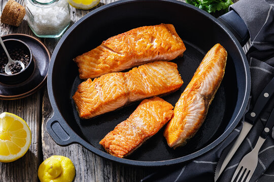 Pan-seared salmon fillets on a skillet, close-up