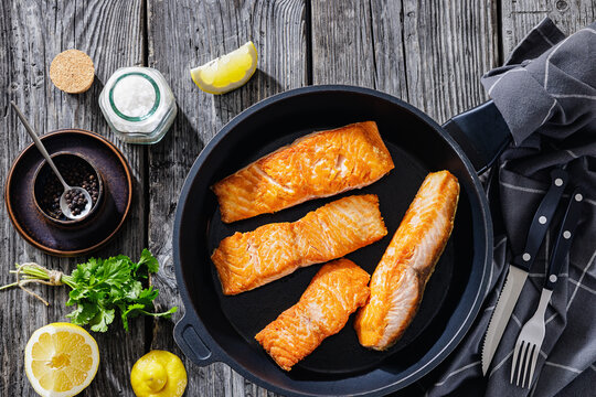 Pan-seared salmon fillets on a skillet, close-up