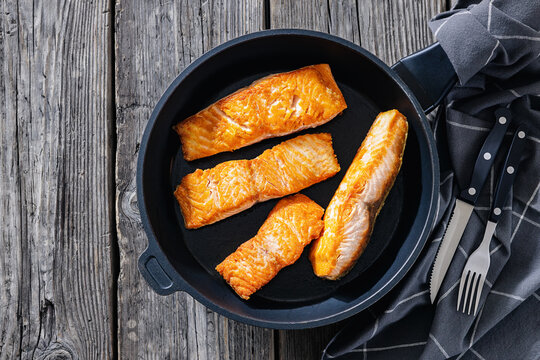 Pan-seared salmon fillets on a skillet, close-up