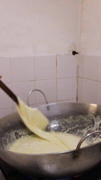 An unrecognizable man is spinning a delicious cheese for the production of a typical Colombian Quesillo inside a factory in Yaguara, Huila, Colombia. Concept of artisanal food and handmade 
