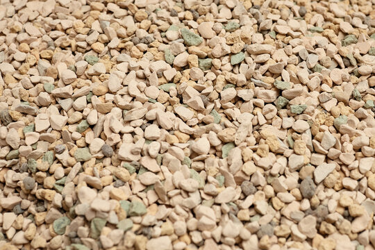 Mineral substrate soil composed of small, irregularly shaped stones in various shades of beige and green, ideal for succulent plants and gardening applications