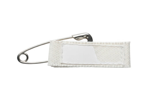 A single silver safety pin holding a small rectangular white fabric label tag