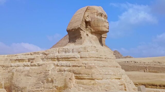 Famous egyptian landmark, the great sphinx of giza, standing on the desert plateau with the pyramids in the background on a sunny day
