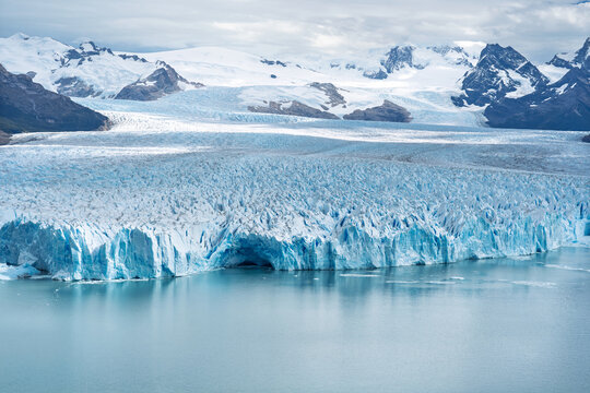 Perito Moreno Glacier in Los Glaciares National Park, Patagonia, Argentina. Massive blue ice wall meeting the water under a cloudy sky.