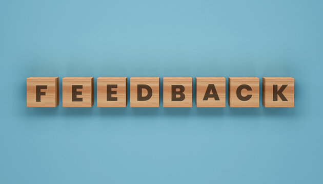 Feedback spelled in Blocks: The word FEEDBACK is elegantly spelled out using wooden blocks against a muted blue backdrop, evoking a sense of clarity, communication and constructive input.