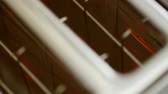 Close up glowing heating elements inside white toaster in warm kitchen lighting