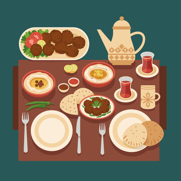 A top-down view of a traditional Middle Eastern meal laid out on a table, featuring falafel, hummus, bread, and tea.