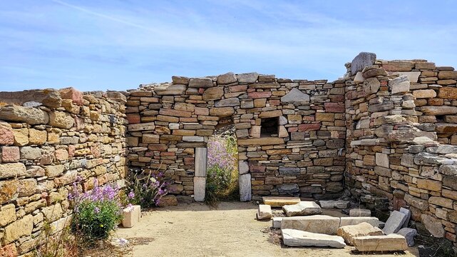 Photo of the ruins of an ancient shop in the Agora of the Competaliasts on the island of Delos, Greece. 