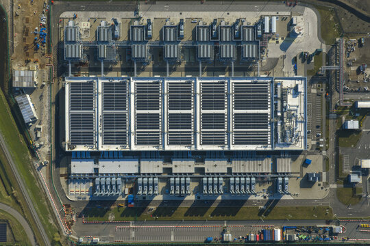 Aerial view of an AI data center with cooling towers and cloud computing hub exterior featuring industrial infrastructure and technical equipment.