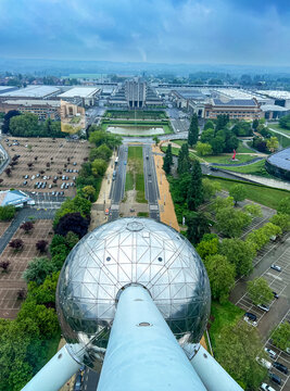 Brussels, Belgium - May 6, 2026: Elevated view from the Atomium showing the Brussels Expo complex, landscaped grounds, parking areas and surrounding urban landscape under overcast skies.