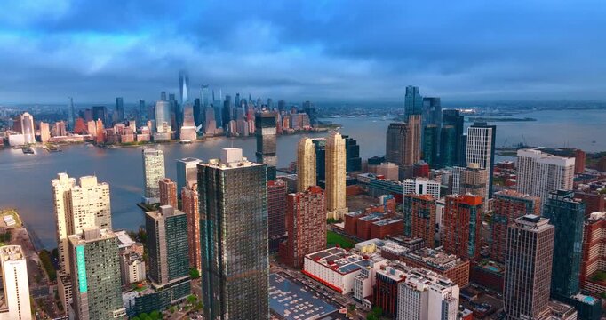 Grey cloudscape covers the sky over majestic skyscrapers of Jersey City and Manhattan. Moving slow over the modern urban landscape on cloudy day.