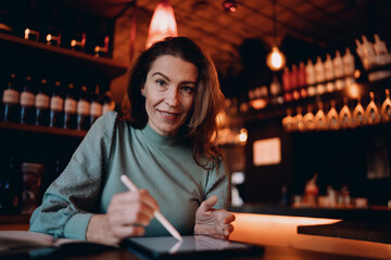 Portrait of Caucasian female professional using tablet with stylus, creative designer looking at...