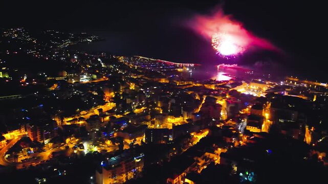 Night aerial perspective of Sanremo marina and waterfront glowing under dark sky