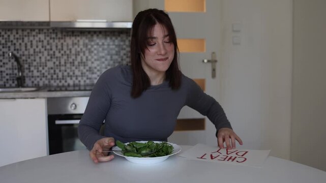 Woman gives up on strict dieting and happily chooses cheat day with chocolate after healthy meals showing relatable struggle with cravings and modern food habits