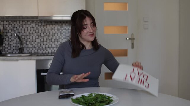 Nutrition specialist smiling during cheat day while combining healthy salad with chocolate showing mindful eating balance and modern positive attitude toward food