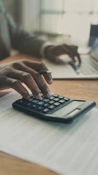 Close-up view man's hand using a calculator
