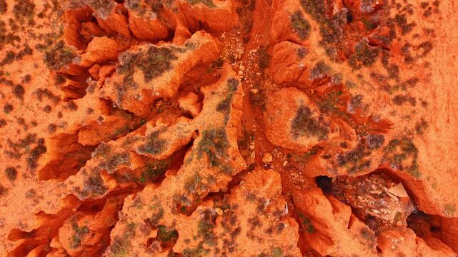 Amazing highly textured landscape of orange and reddish-brown tones. Aerial view of a layered sandstone canyon with poor vegetation. Teruel, Spain.