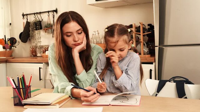 The mother sat at the dining table helping her daughter with her homework, while the daughter happily wrote in her notebook at home.