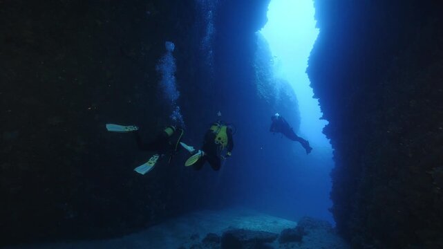 cave diving underwater scuba divers exploring caves and having fun ocean scenery sun beams and rays background