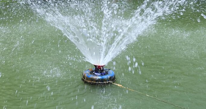 Fountain spraying water, Water aerator splashing in a fish pond, improving oxygen and water quality for aquaculture, sustainable farming, and clean energy concepts