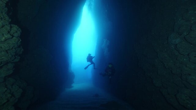 cave diving underwater scuba divers exploring caves and having fun ocean scenery sun beams and rays background