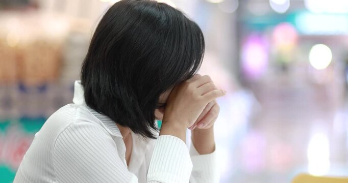 Young woman sadness and shock in a public place, representing stress, anxiety, emotional problems, mental health, and human feelings