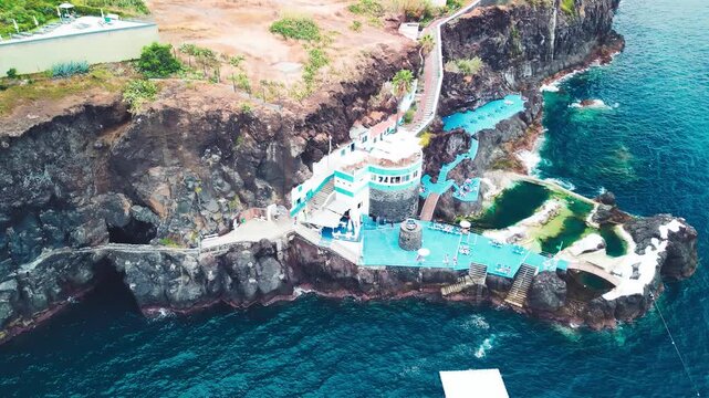 Aerial summer view of Doca do Cavacas in Madeira, capturing turquoise waters, moored boats, and vibrant coastal scenery
