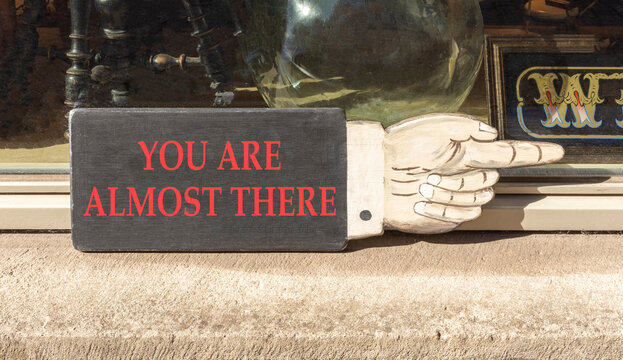 You are almost there words symbol. Concept words You are almost there on beautiful wooden sign. Beautiful shopfront background. Business You are almost there motivational support concept. Copy space