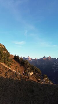 Drone view of two hikers walking on ridge stairs at Stoos Fronalpstock, Switzerland