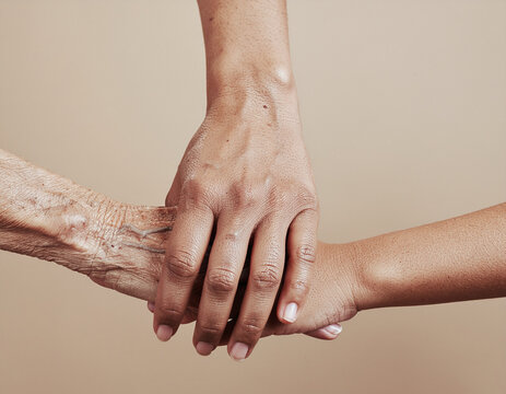 a close up shot of three hands from different generations stacked together against a neutral background, representing family heritage, care, and unity
