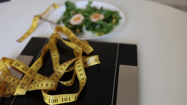 Bathroom scale and measuring tape near healthy salad show weight loss pressure diet control and body image anxiety turning a simple meal into modern food stress and guilt