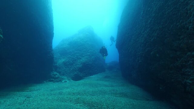 cave diving underwater scuba divers exploring caves and having fun ocean scenery sun beams and rays background
