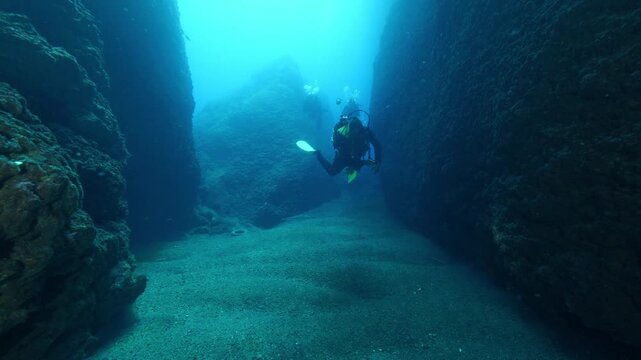 scuba divers are swimming next to walls underwater wall dive