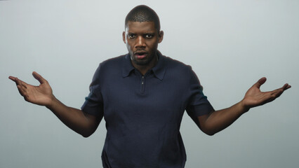 Fototapeta premium Man pinching bridge of nose with hand and folded arm in studio wearing polo shirt, then opens hands in a shrug sequence; frustration tension.