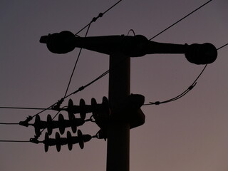 Obraz premium electric coulumn with wires sunset