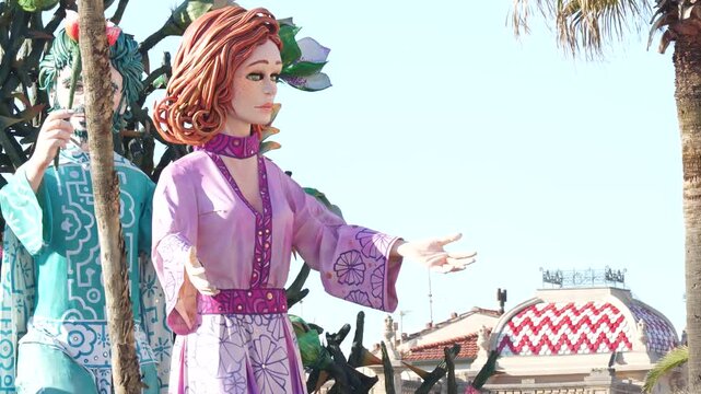 Sunny daytime parade of satirical masked carri allegorici advancing on Viareggio passeggiata mare Italy festival