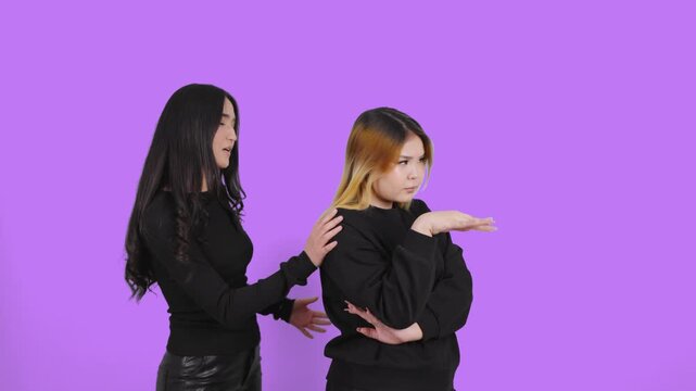 Young woman trying to reconcile with her angry friend