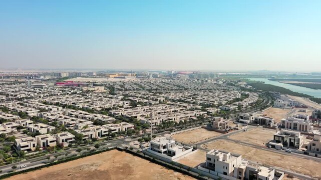 Aerial view of the modern Yas Acres residential community on Yas Island, Abu Dhabi, UAE, featuring luxury villas, contemporary architecture, and lush suburban development near the mangroves.
