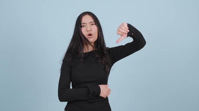 Young woman showing a thumb down gesture of disapproval