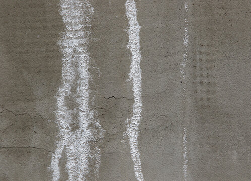 white efflorescence salt deposits on a grey concrete wall