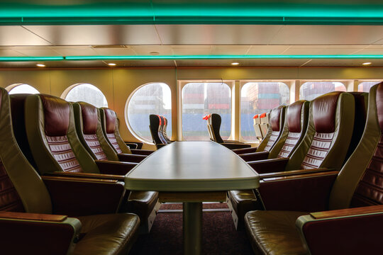 Empty passenger lounge seats inside modern ferry boat with sea view