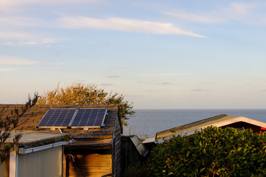 Small solar panels installed on garden shed roof by the sea