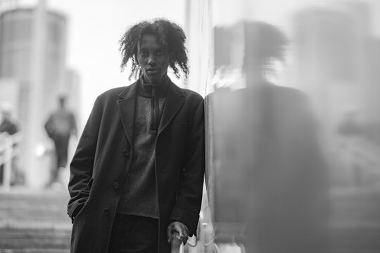 Confident Young Man with Reflection in City Window Monochrome Style with Copy Space