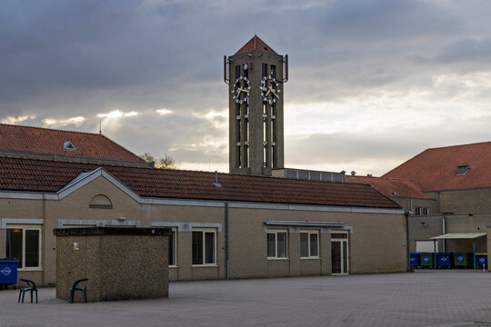 Veldhoven, Netherlands. View of the iconic brick clock tower and traditional architecture of the NH Koningshof hotel and conference center under a cloudy sky.