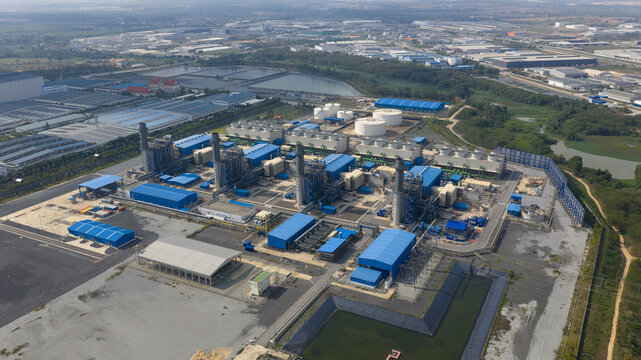 Aerial view of Gulf Pluak Daeng Power Plant with blue industrial buildings, cooling towers, and storage tanks in Map Yang Phon, Rayong, Thailand.